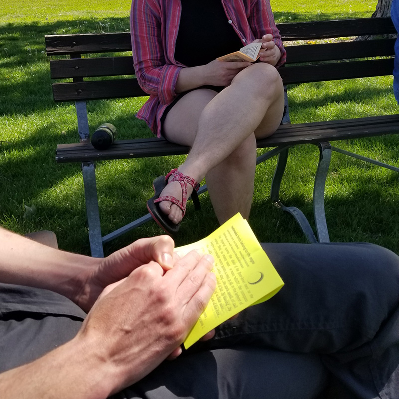 Image depicts two hands holding a yellow piece of paper with words for the read-aloud activity.